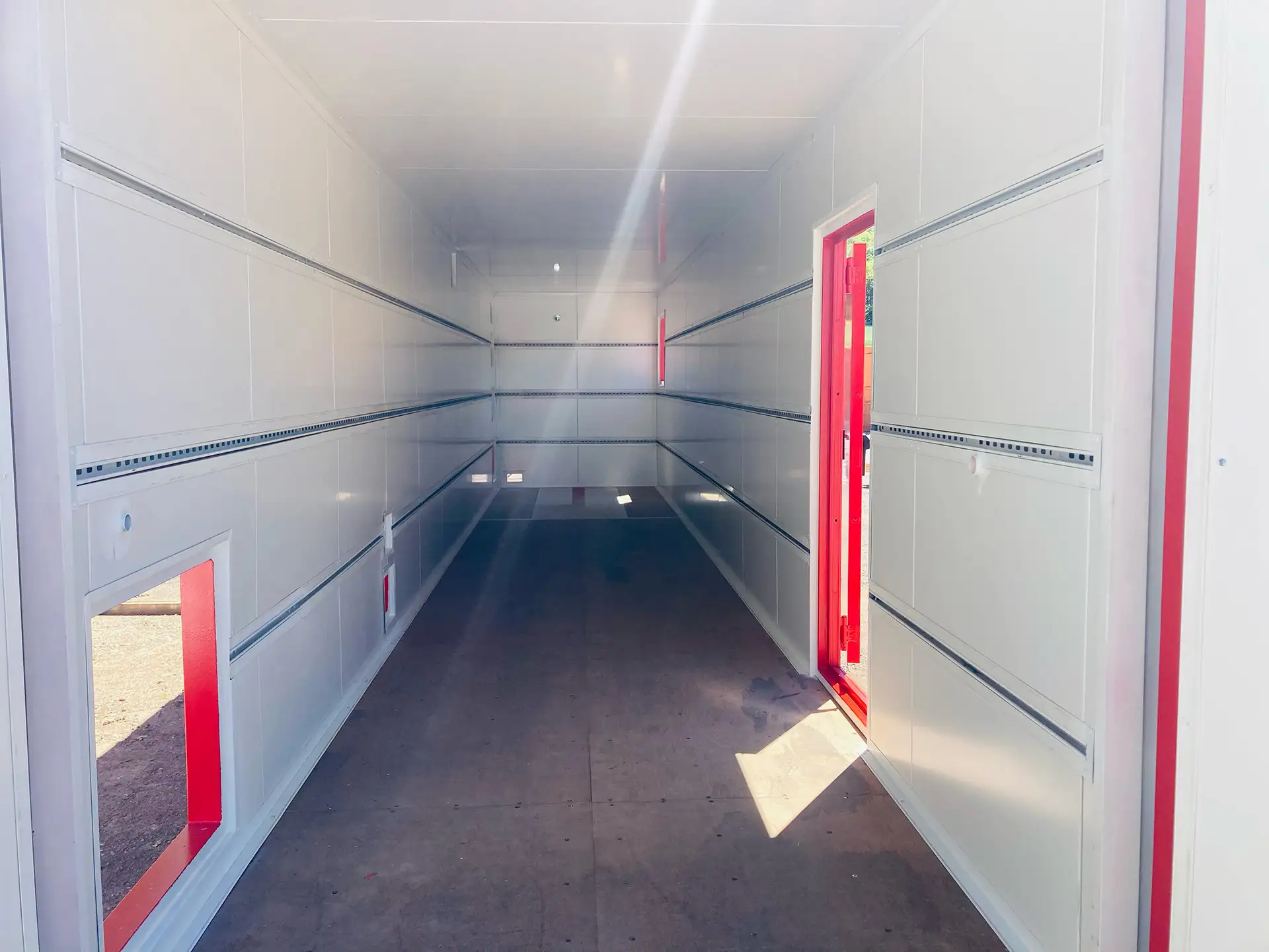 Intérieur d'un conteneur isolé avec rail de support et trappe de passage de cables et grille d'aérations.